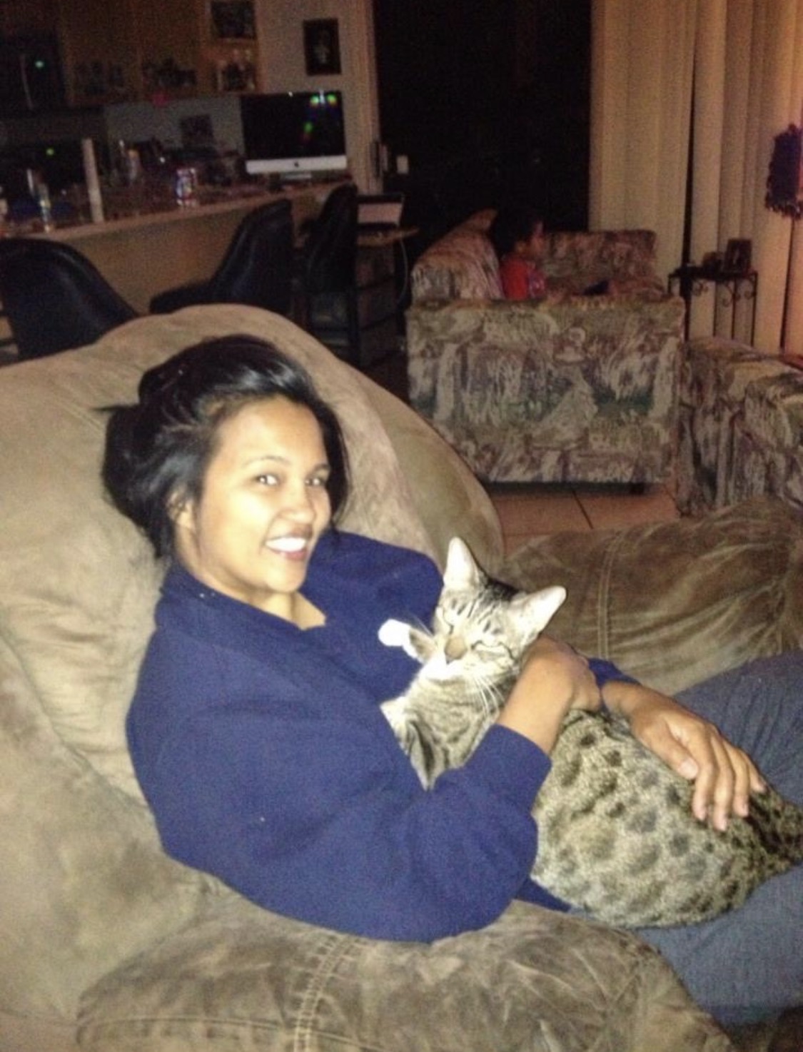 Cuddling a content tabby cat on the couch